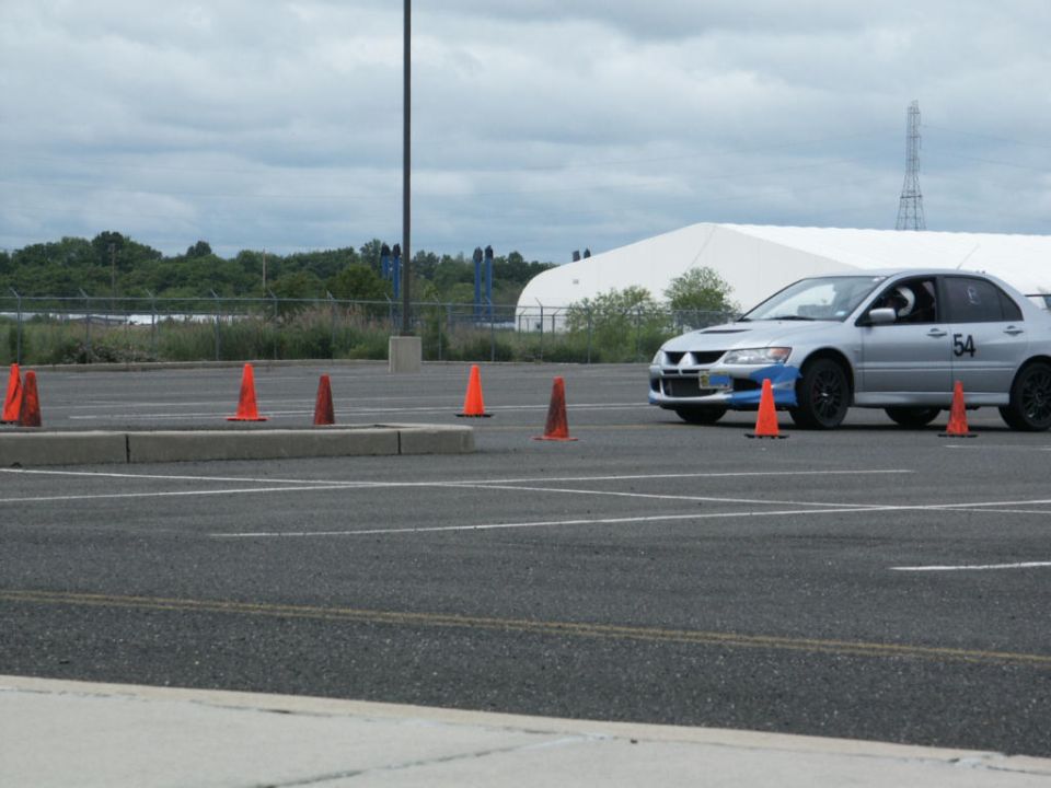 Silver sedan with blue accents and number 54 on door, navigating a cone course