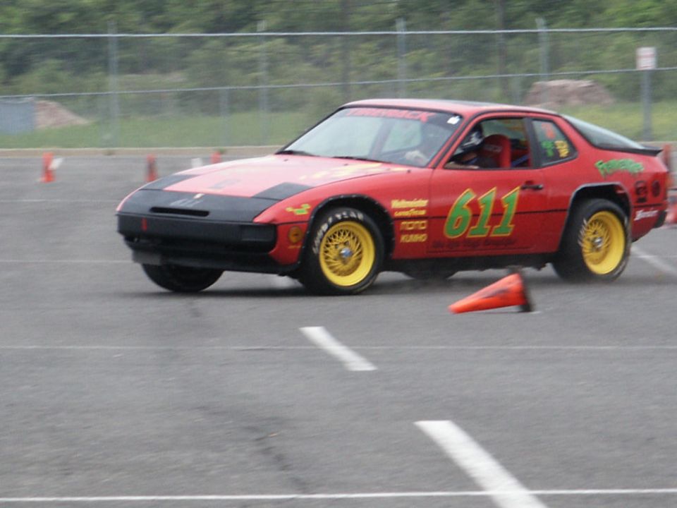 Red race car with yellow wheels and number 611 on side, on track