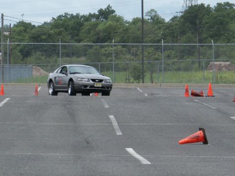 2001 Mercury Grand Marquis - Gray Ford Mustang navigates a course marked by orange cones on a paved lot.