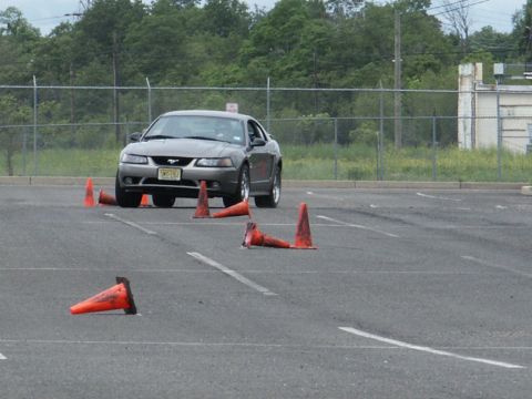2001 Mercury Grand Marquis - A gray Ford Mustang is shown on a closed course, maneuvering around traffic cones.