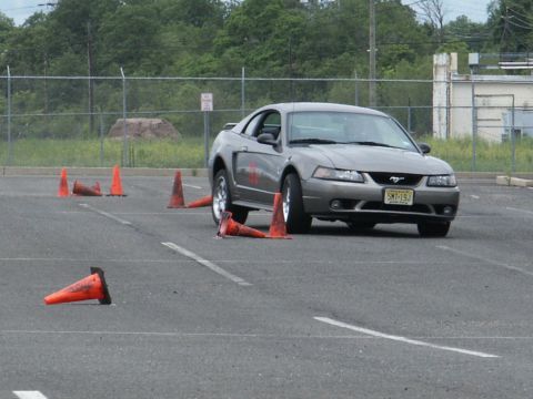 2001 Mercury Grand Marquis - Gray Ford Mustang navigates an obstacle course marked by orange traffic cones.