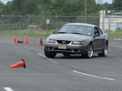 2001 Mercury Grand Marquis - A gray Ford Mustang navigates an autocross course marked by orange cones.