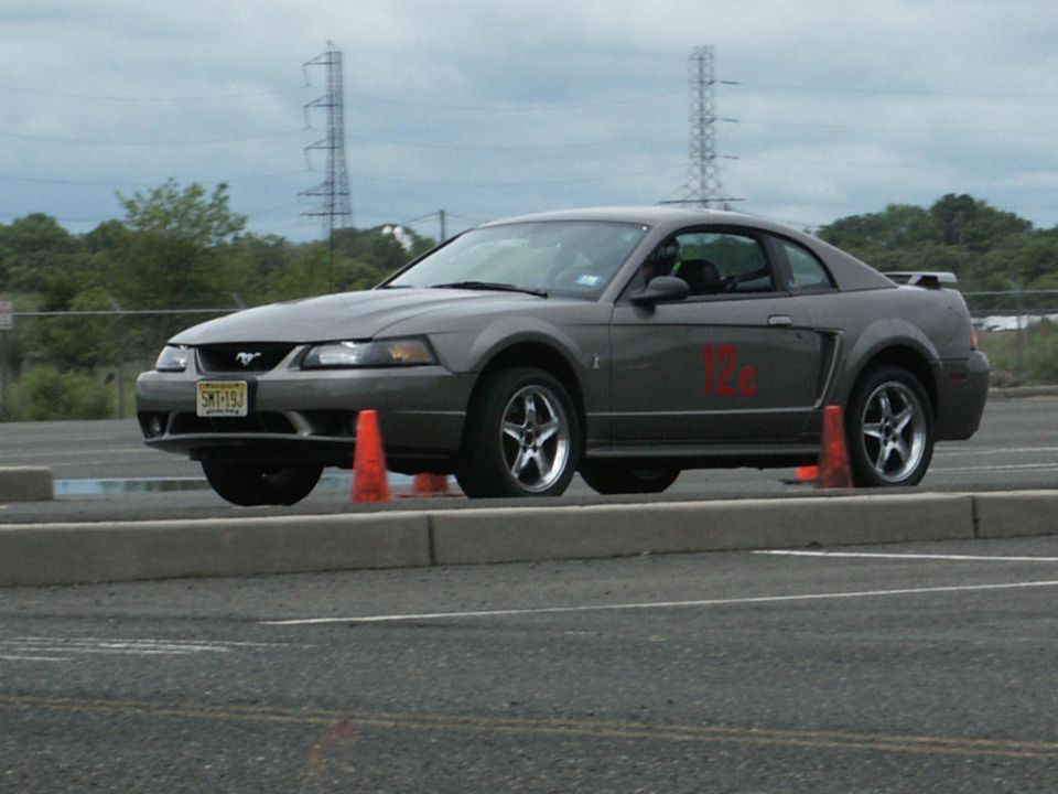 Gray Ford Mustang coupe with red side decal, seen from the front three-quarter angle