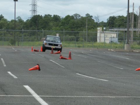 2001 Mercury Grand Marquis - Volkswagen Rabbit navigates an obstacle course marked by orange cones in an empty parking lot.