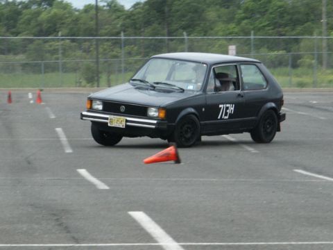 2001 Mercury Grand Marquis - A black Volkswagen Rabbit GTI is seen on a paved course with orange cones, likely participating in an autocross event.