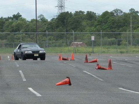 2001 Mercury Grand Marquis - A black Ford Mustang is shown on a paved lot with several orange cones scattered around.