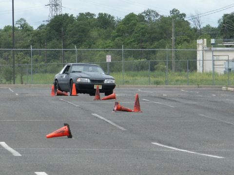 2001 Mercury Grand Marquis - A Ford Mustang is shown maneuvering through an obstacle course marked by traffic cones.