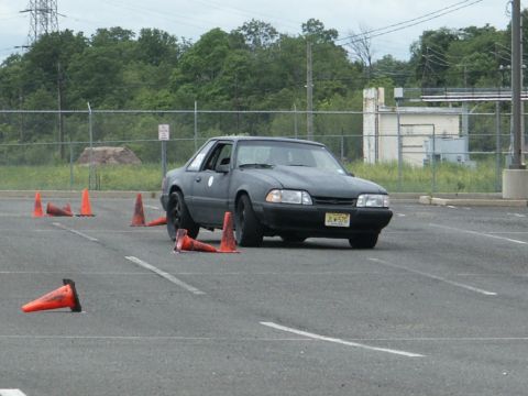 2001 Mercury Grand Marquis - A dark coupe navigates a cone course, its license plate JCW-576 visible.