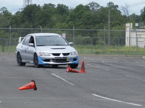 2001 Mercury Grand Marquis - Mitsubishi Lancer Evolution VIII participating in a timed event on a paved course with traffic cones.