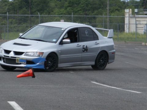2001 Mercury Grand Marquis - A silver sedan with racing modifications is seen on a track with an orange cone nearby.