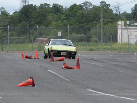 2001 Mercury Grand Marquis - A yellow sports car is shown navigating a course marked by orange traffic cones.