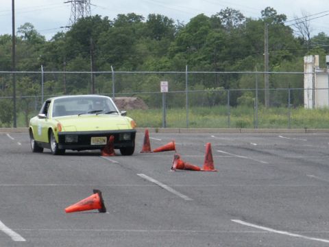 2001 Mercury Grand Marquis - A yellow sports car navigates a course marked by traffic cones in an asphalt lot.
