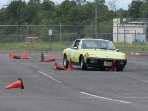2001 Mercury Grand Marquis - A yellow sports car maneuvers through an obstacle course marked by orange traffic cones.