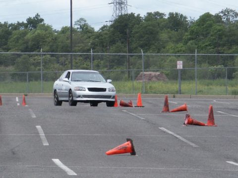 2001 Mercury Grand Marquis - A silver sedan drives through a cone course on a paved lot.