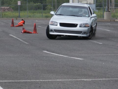 2001 Mercury Grand Marquis - A silver sedan is shown maneuvering through an obstacle course marked by traffic cones.