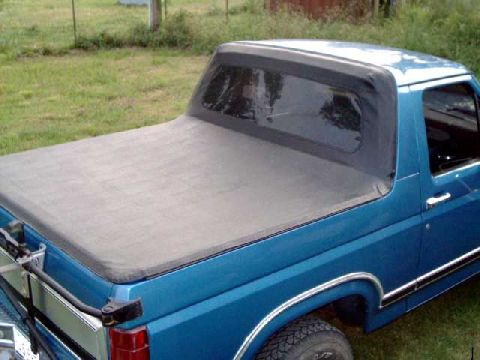 1984 Ford Bronco - Pickup truck with a soft tonneau cover, likely from the 1980s.