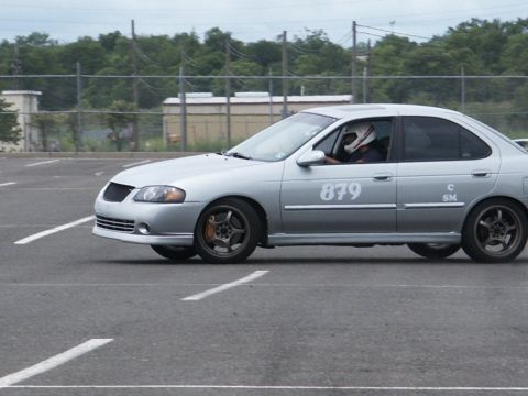 2001 Mercury Grand Marquis - Silver sedan with racing number 879 and SM decal on the side, seen in a parking lot with racing lines.