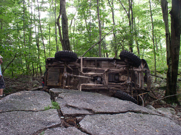 Overturned vehicle on rocks in forest