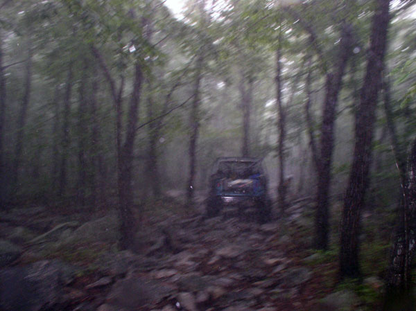 Blue SUV on a rocky trail in a forest