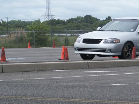 2001 Mercury Grand Marquis - A silver sedan maneuvers through an obstacle course marked by orange traffic cones.