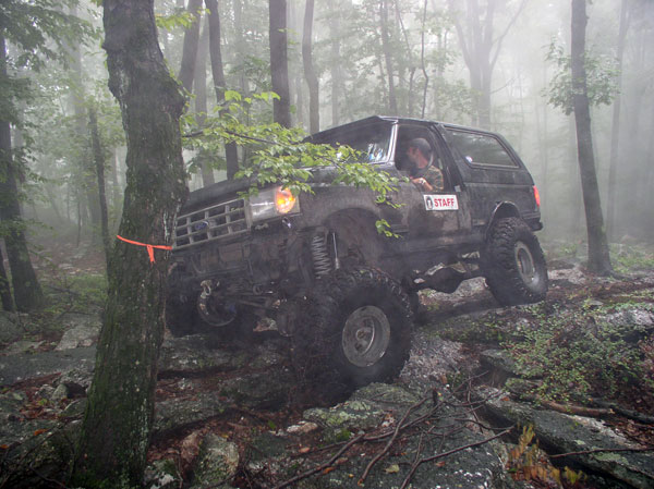 Black 1988 Ford Bronco off-roading on rocky terrain