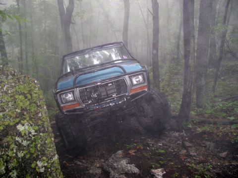 1988 Ford Bronco - Ford Bronco tackling a difficult off-road course in a foggy forest.