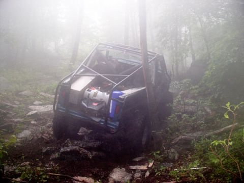 1988 Ford Bronco - Modified off-road vehicle navigating a difficult, foggy trail.