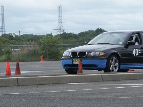 2001 Mercury Grand Marquis - A black BMW 3 Series sedan, possibly from the early 2000s, navigates a course marked by orange cones.