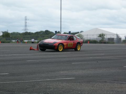 2001 Mercury Grand Marquis - A red sports car with racing numbers navigates a course marked by orange cones.