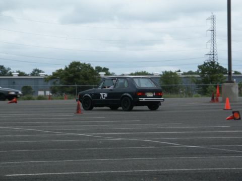 2001 Mercury Grand Marquis - A black Volkswagen Golf Mk1 is driven on a paved lot with orange cones.