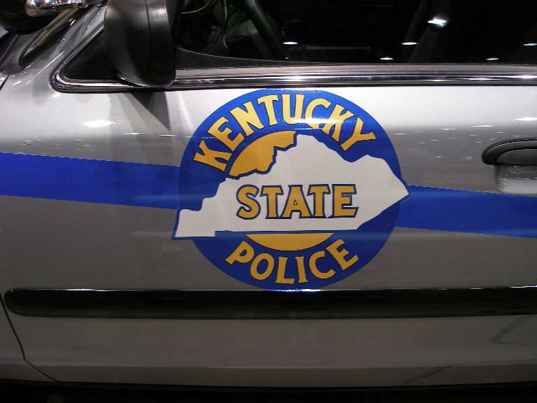 Silver Crown Victoria door with round Kentucky State Police decal and blue stripe