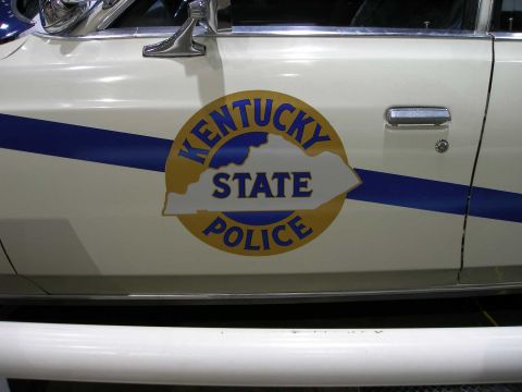 1998 Ford Crown Victoria - Close-up of a cream/white car door bearing the round gold, blue and white 'Kentucky State Police' emblem with the state outline, crossed by…