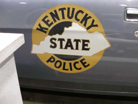 1998 Ford Crown Victoria - Close-up of a gray car door bearing a gold Kentucky State Police decal, with the white outline of the state of Kentucky in the center and a…