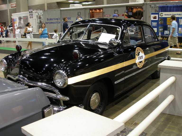 Restored black 1949-style Ford Kentucky State Police cruiser on indoor display