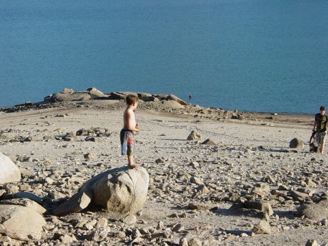 1986 Ford Bronco - A boy surveys the landscape from a rocky shore next to a large body of water.