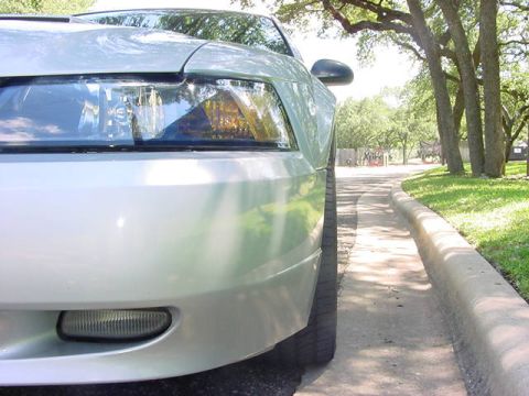 1999 Ford Mustang - Front view of a 1999 Ford Mustang, focusing on the headlight and bumper details.