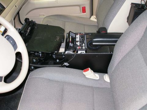 1998 Ford Crown Victoria - Interior of a police-equipped vehicle showing a gray cloth front seat with a black center-mounted equipment console holding a laptop mount,…