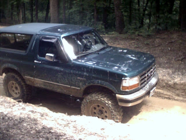 1996 Ford Bronco stuck in mud on a wooded trail