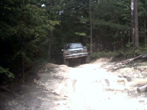 1996 Ford Bronco - A 1997 Ford F-250 navigates a challenging dirt path through a wooded area.