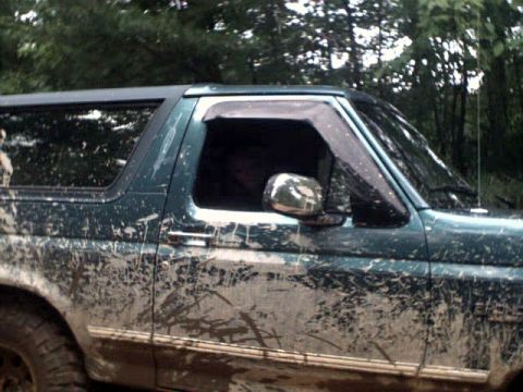 1996 Ford Bronco - Muddy 1996 Ford Bronco side view with trees in the background.