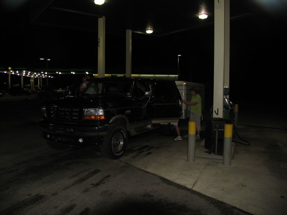 1995 Ford C-350 (Centurion Conversions) at a gas station at night, driver's side door open
