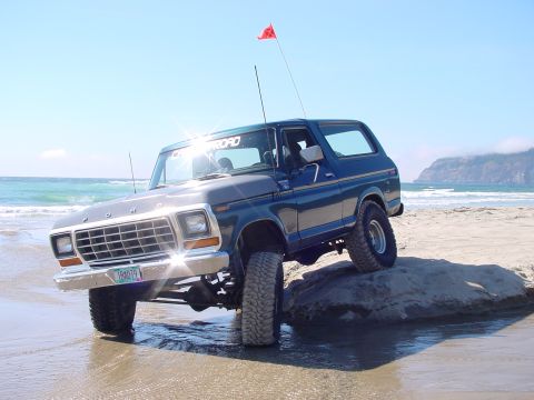1979 Ford Bronco - A 1978 Ford Bronco navigates a rocky beach with the ocean waves crashing nearby.