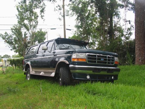 1995 Ford C-350 (Centurion Conversions) - 1995 Ford C-350 Centurion Conversions SUV parked on grass with trees in the background.