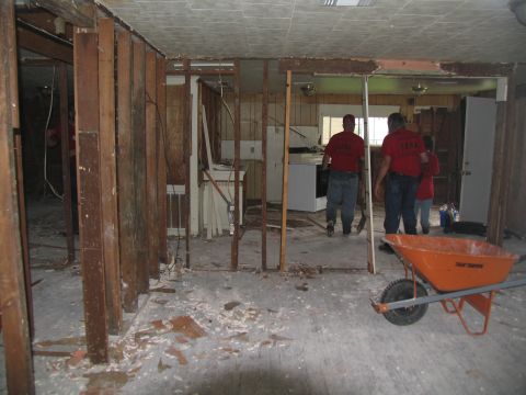1995 Ford C-350 (Centurion Conversions) - Demolition work is underway inside a building, with debris scattered across the floor and walls partially dismantled.