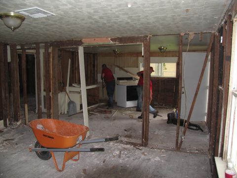 1995 Ford C-350 (Centurion Conversions) - Workers are in the process of demolishing an interior space, with debris scattered on the floor.