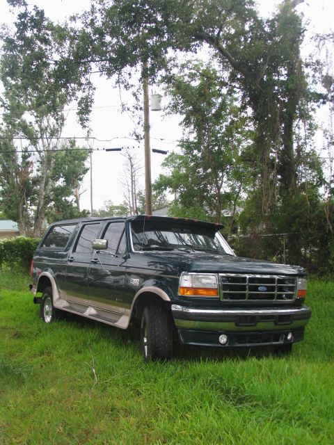 1995 Ford C-350 (Centurion Conversions) - This 1995 Ford C-350 Centurion Conversion SUV is seen parked on a grassy area with trees in the background.