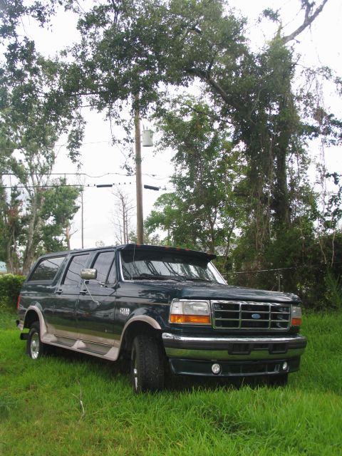 1995 Ford C-350 (Centurion Conversions) - This Ford Bronco Centurion conversion SUV is seen parked in a grassy area with trees overhead.
