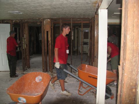1995 Ford C-350 (Centurion Conversions) - Volunteers clear debris from a damaged building, likely after a disaster.