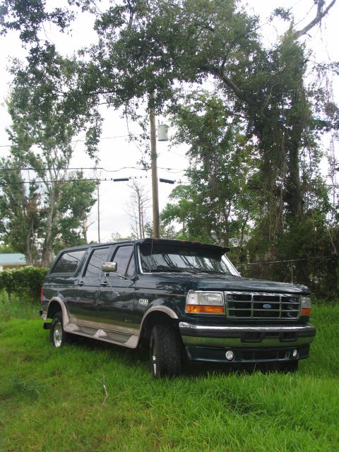 1995 Ford C-350 (Centurion Conversions) - Dark green 1995 Ford C-350 (Centurion Conversions) SUV parked in grassy area.