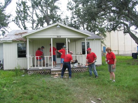1995 Ford C-350 (Centurion Conversions) - Volunteers clean up debris in front of a house after a disaster.